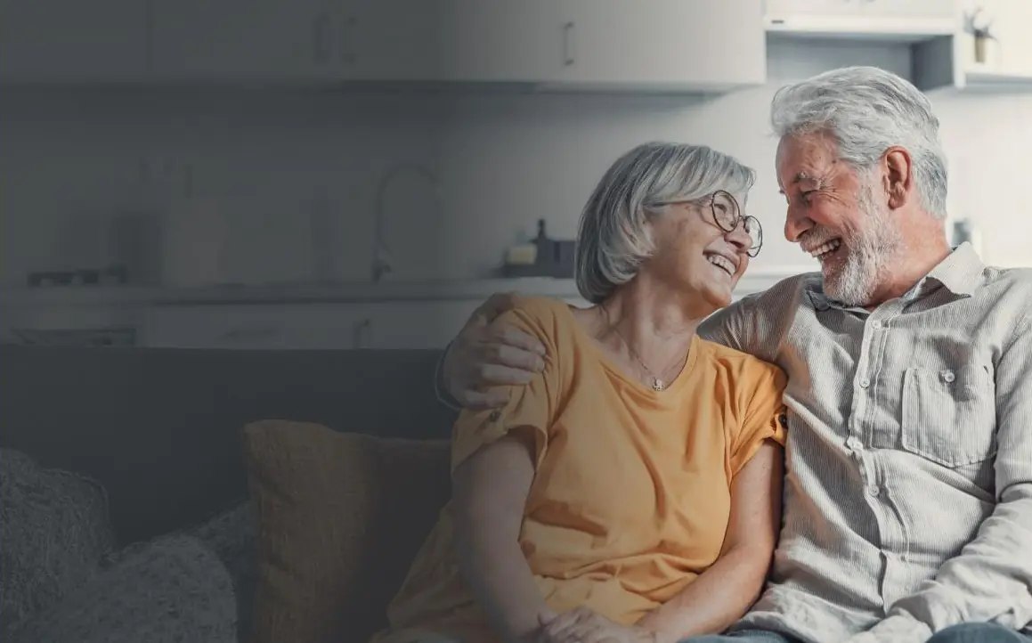 Two residents laughing together in a community living room